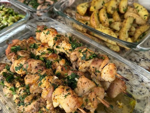 Herb-marinated chicken skewers with roasted potato wedges.