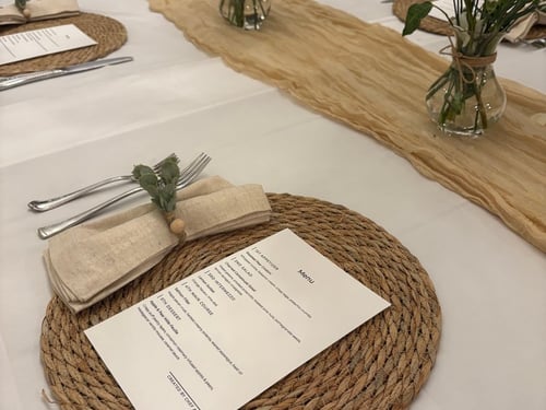 Elegantly set dining table with personalized menus and floral centerpieces.