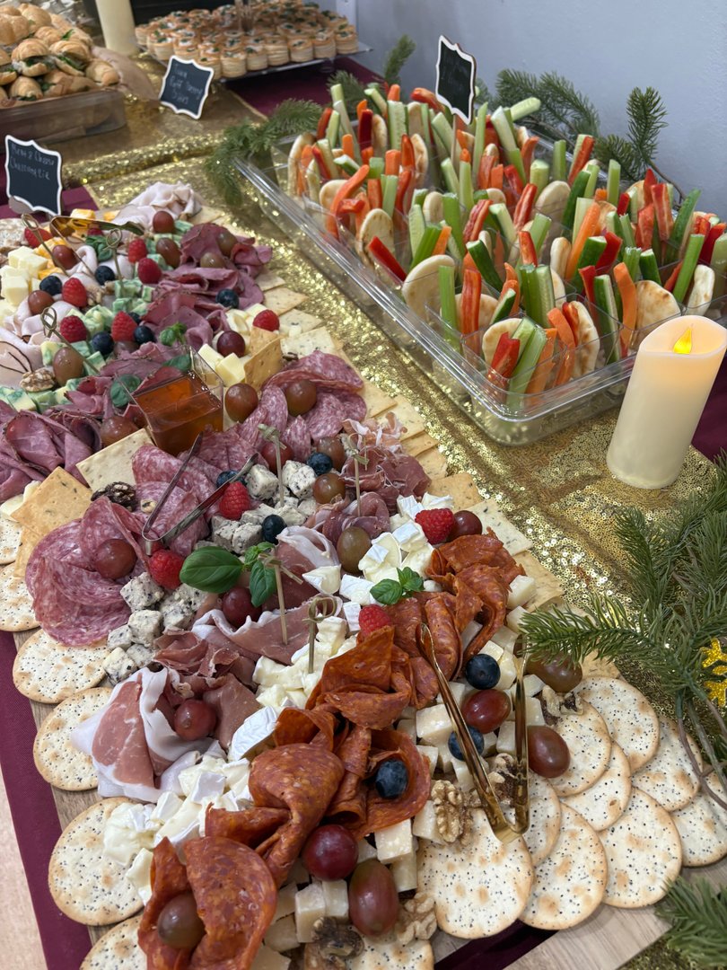 Elaborate charcuterie board with assorted meats, cheeses, fruits, and crackers.