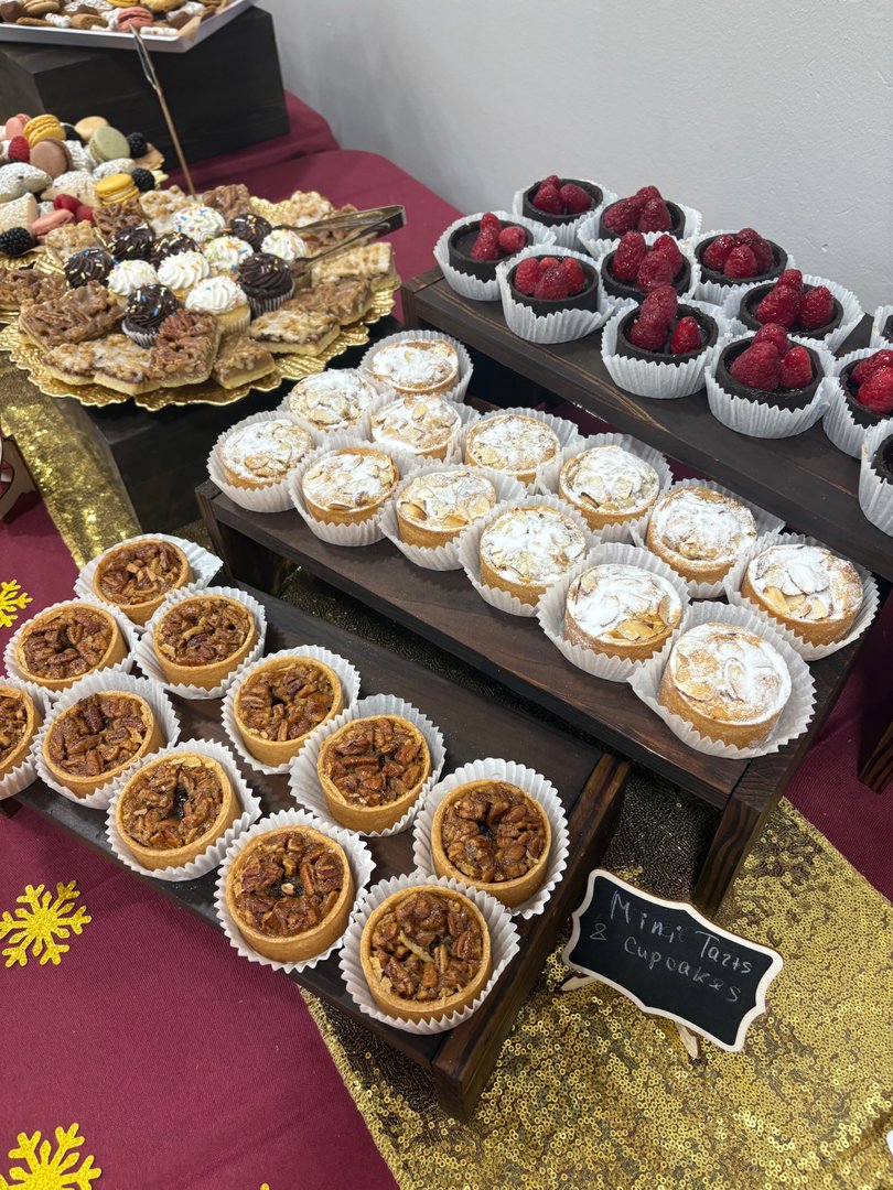 Display of mini pecan tarts, almond tarts, and chocolate raspberry tarts.
