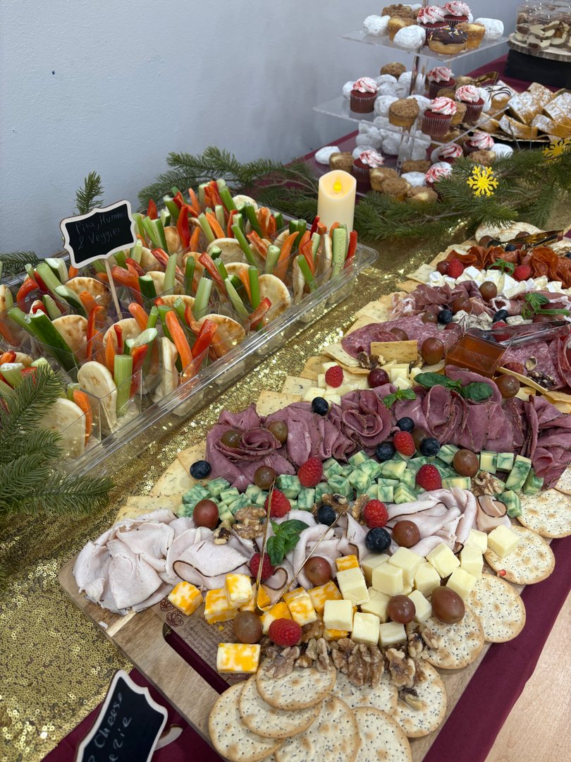 Large charcuterie board with meats, cheeses, crackers, and mini veggie cups.