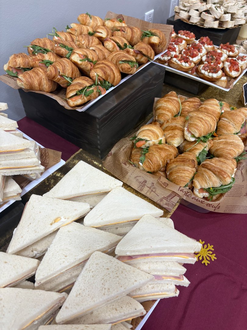 Platter of salmon cream cheese croissants, small sandwiches, and caprese bruschetta.