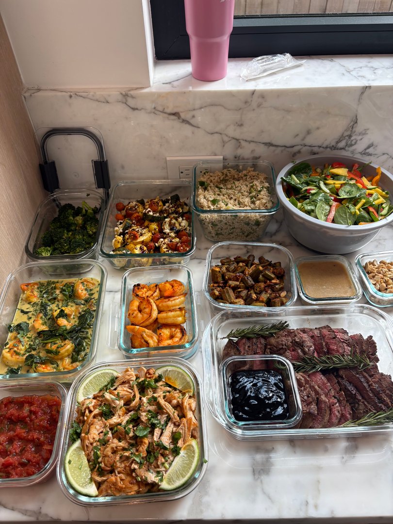 Full spread of gourmet global meal prep containers on a counter.