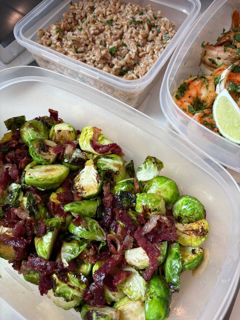 Roasted brussels sprouts with bacon bits in a meal prep container.