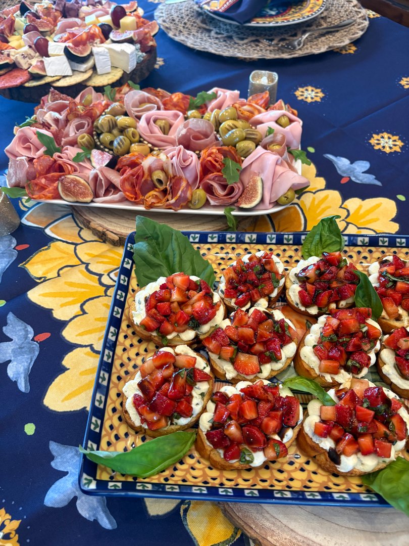 Close-up of strawberry bruschetta with fresh basil and charcuterie.