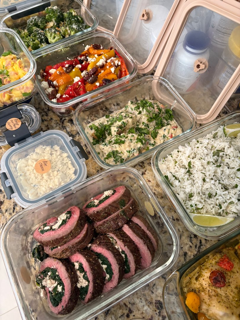 Various meal prep containers with steak pinwheels, rice, and chicken.