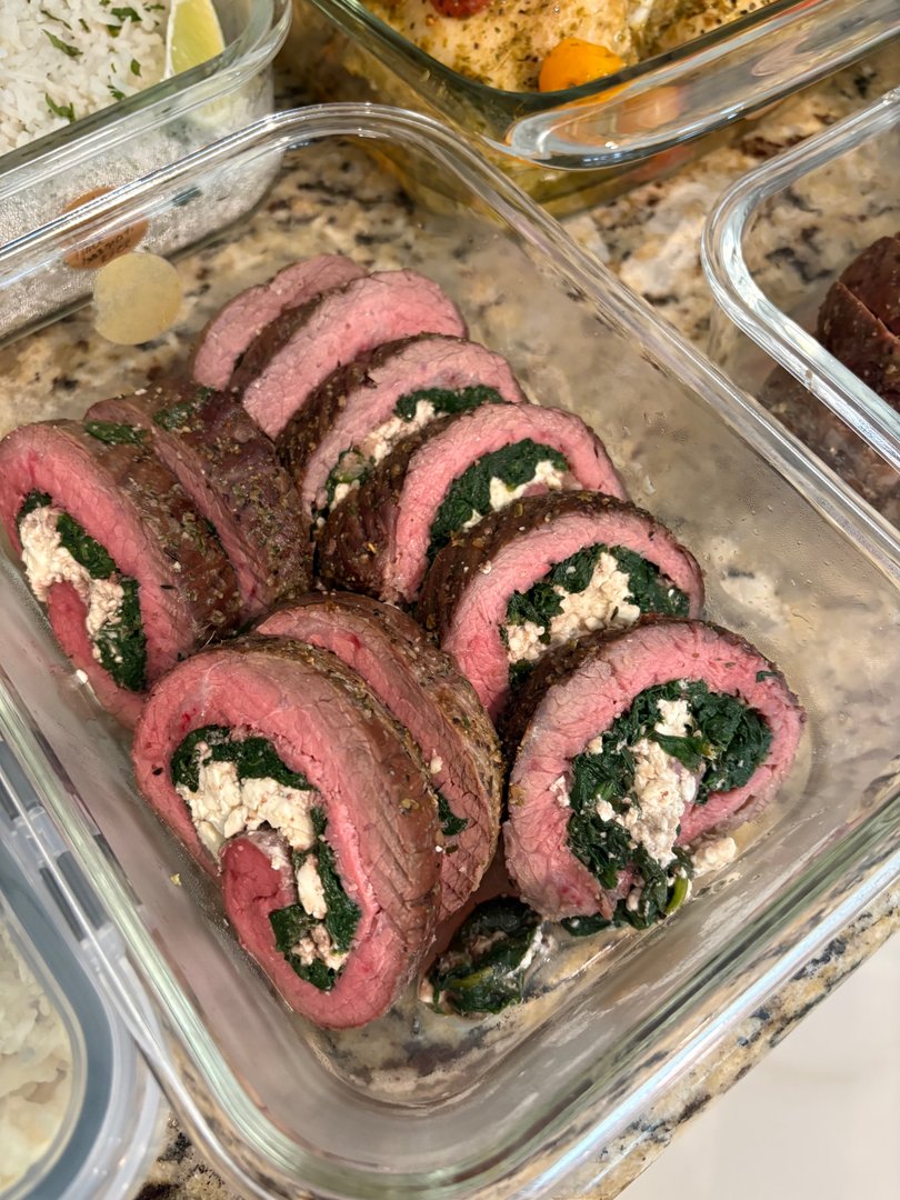 Close-up of sliced steak pinwheels filled with spinach and feta cheese.