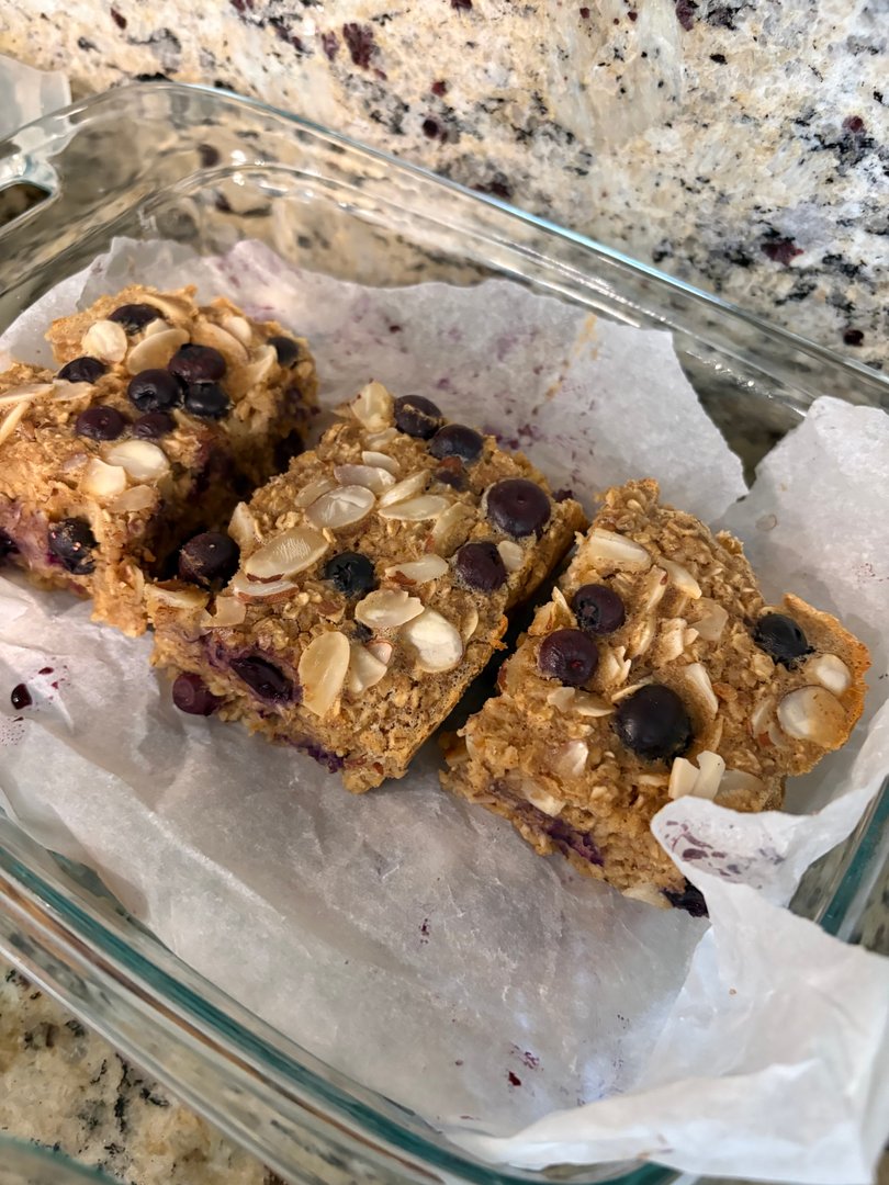 Blueberry oat bars topped with sliced almonds in a glass dish.
