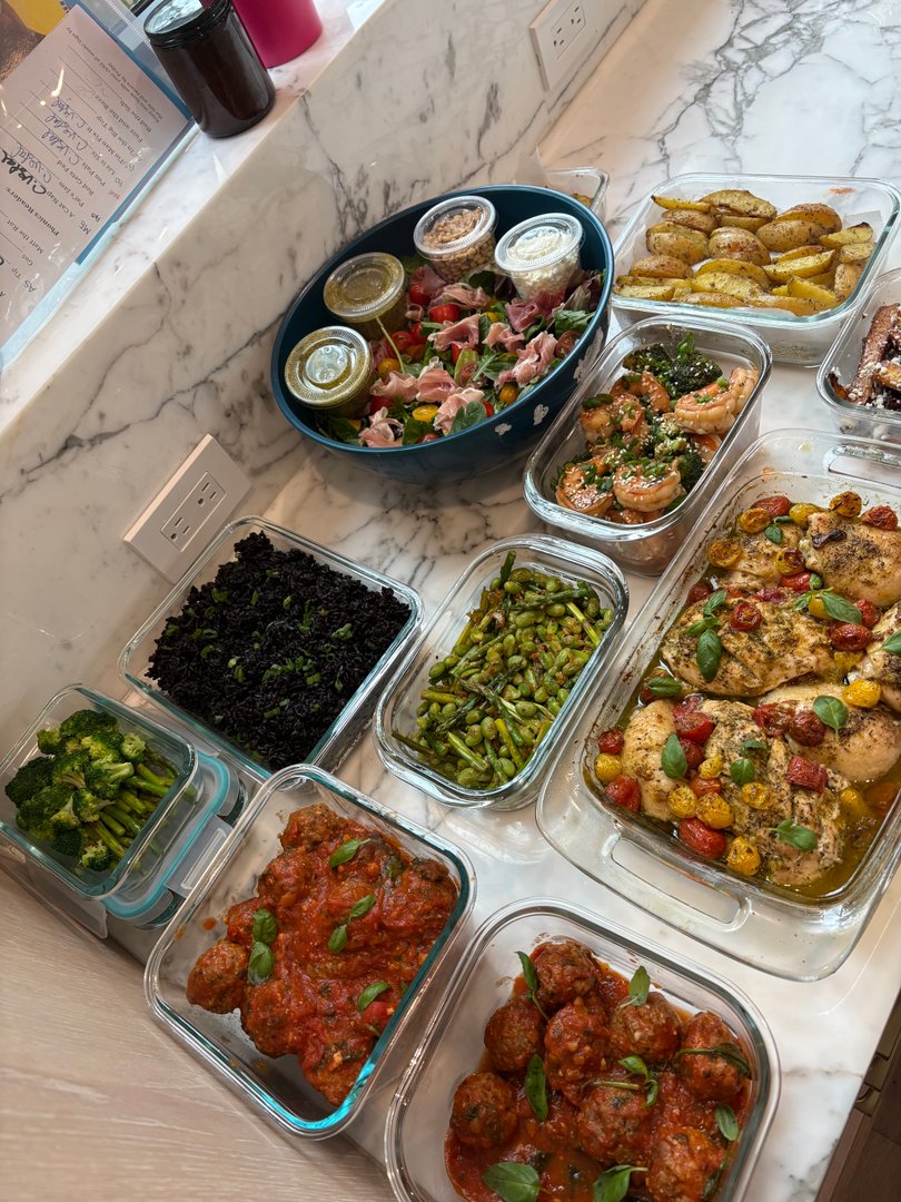 Overhead shot of a full meal prep spread on a marble counter.