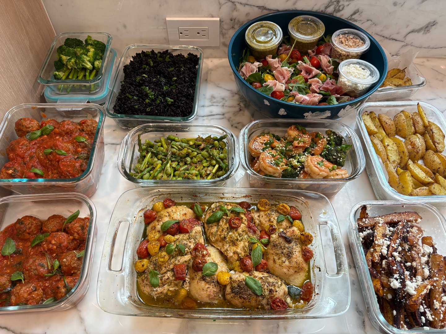 Wide shot of a complete meal prep with multiple dishes ready for storage.