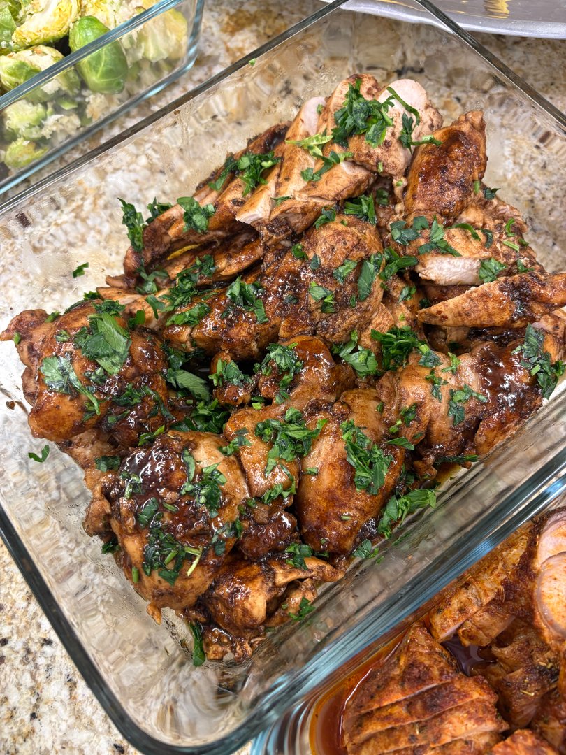 Close-up of seasoned chicken thighs with fresh parsley garnish.