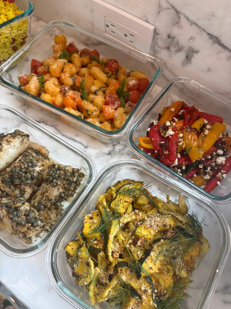 Close-up of gnocchi, roasted peppers, fish, and squash.