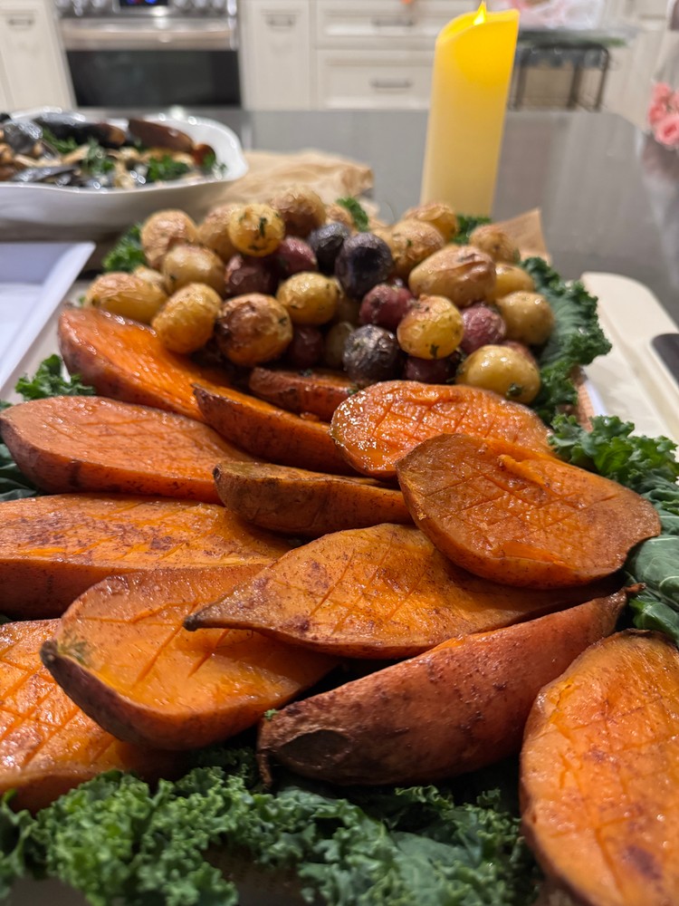 Roasted sweet potato halves and baby potatoes with kale.