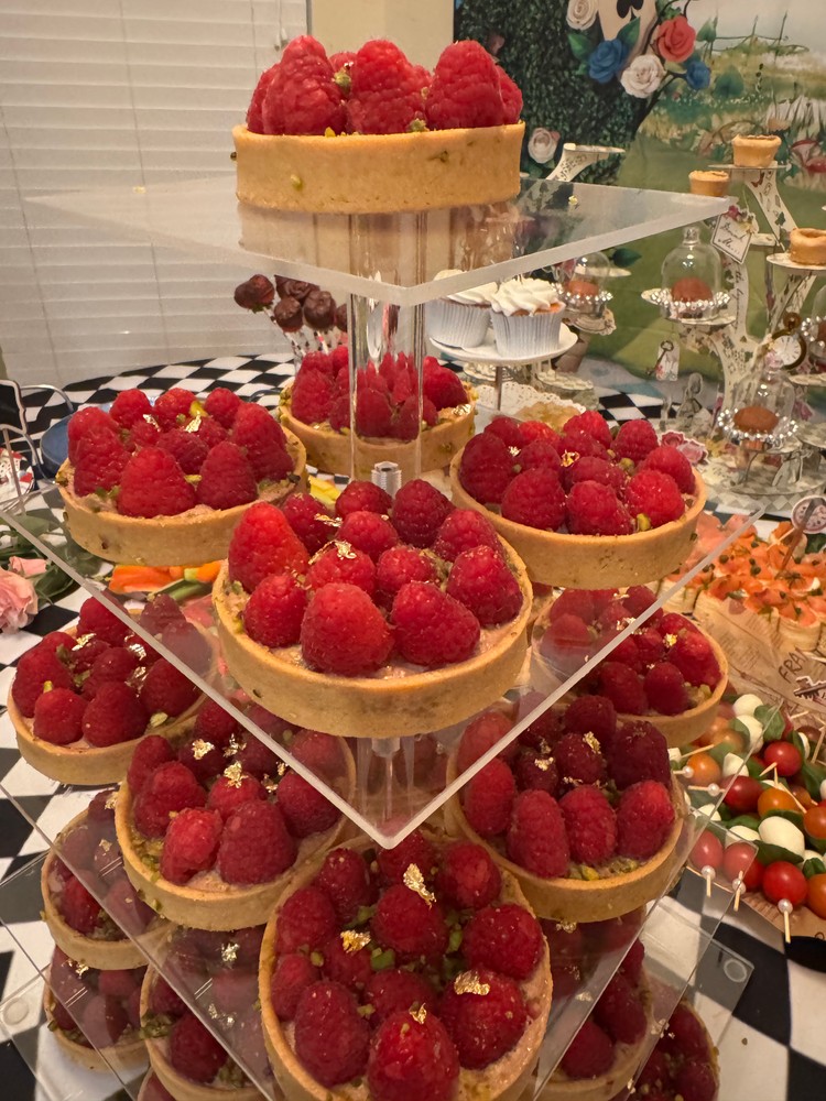 Close-up of tiered raspberry tarts with gold flakes