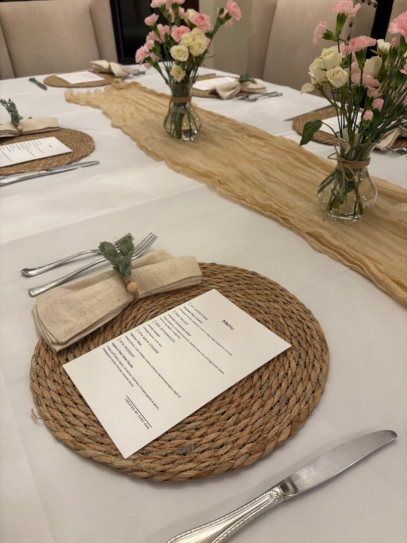 Elegantly set dining table with personalized menus and floral centerpieces.