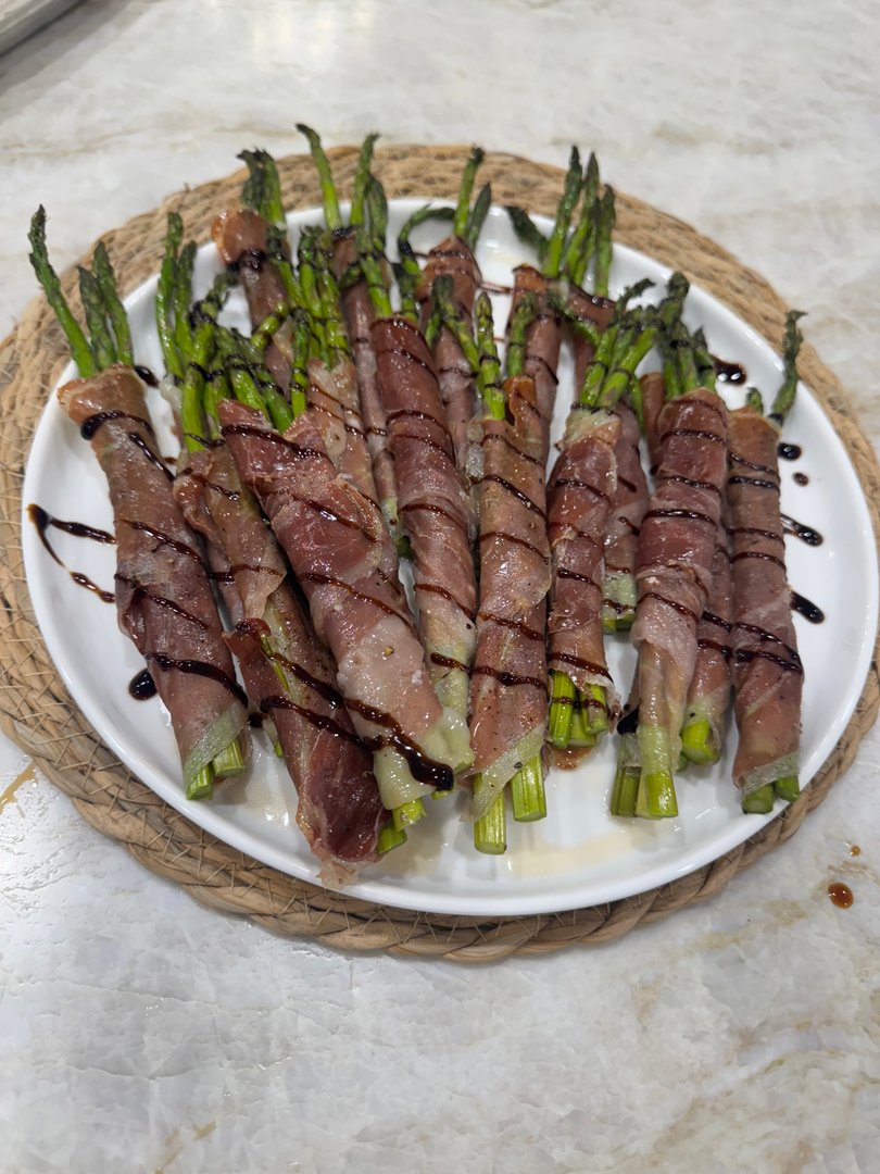 Prosciutto-wrapped asparagus spears drizzled with balsamic glaze.